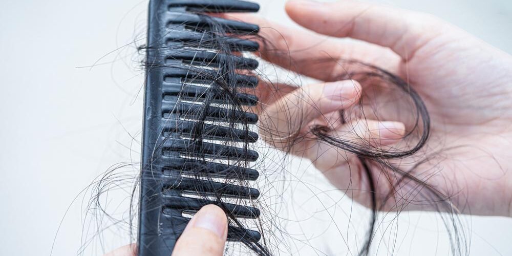 Asian woman have problem with long hair loss attach to comb brus